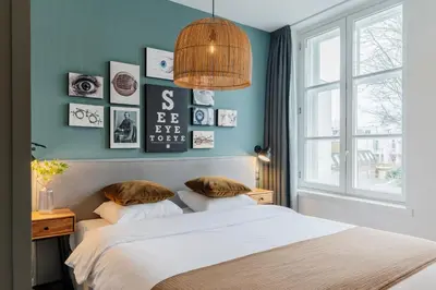 a bedroom with blue walls and a bed with pillows at Eye Hotel in Utrecht
