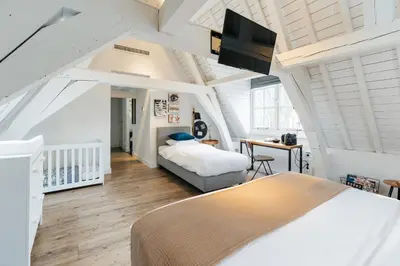a bedroom with two beds and a flat screen tv at Eye Hotel in Utrecht