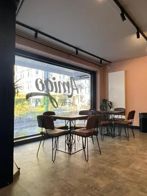 a dining room with tables and chairs in front of a window at Amigo Hotel in Amsterdam