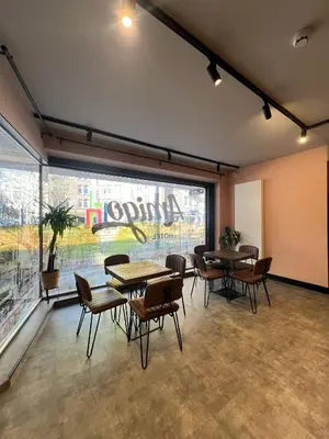 a room with tables and chairs and a large window at Amigo Hotel in Amsterdam