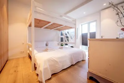 a bedroom with a bunk bed with white sheets at Villa Beachhouse in Bergen aan Zee