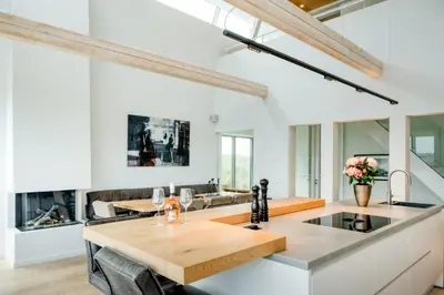 a kitchen and living room with white walls and a table at Villa Beachhouse in Bergen aan Zee