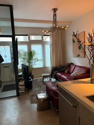 a living room with a red leather couch and a chandelier at Quartier Museum Center Amsterdam in Amsterdam