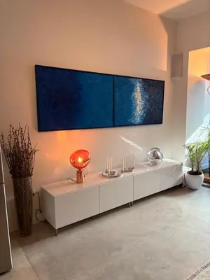 a living room with a white table with a large painting on the wall at Quartier Museum Center Amsterdam in Amsterdam