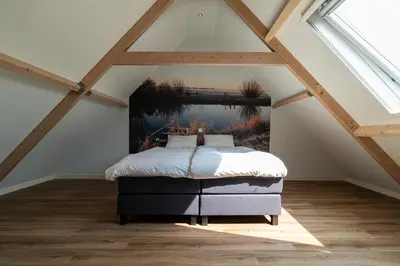 a bedroom with a bed in a attic at Maria's hoeve Abcoude huisje 2 dichtbij Amsterdam in Abcoude