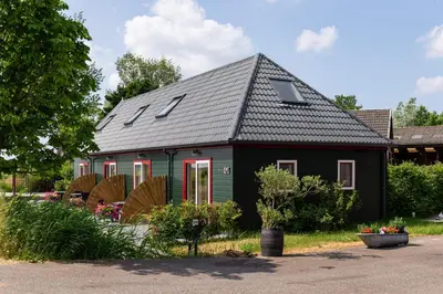 a small green house with a black roof at Maria's hoeve Abcoude huisje 2 dichtbij Amsterdam in Abcoude