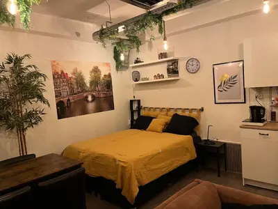 a bedroom with a bed and a couch at The Studio no windows 20 minutes by bus to downtown Amsterdam in Purmerend