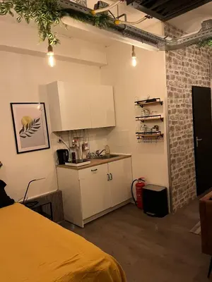 a kitchen with white cabinets and a counter in a room at The Studio no windows 20 minutes by bus to downtown Amsterdam in Purmerend