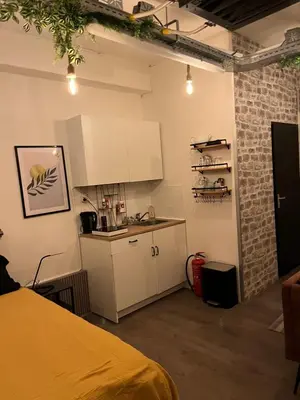a kitchen with white cabinets and a counter in a room at The Studio no windows 20 minutes by bus to downtown Amsterdam in Purmerend