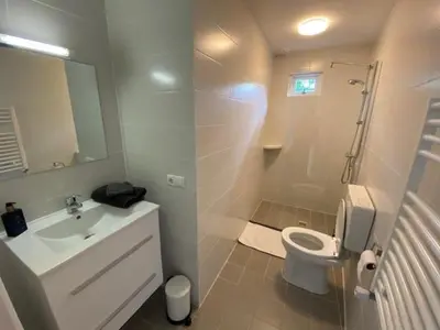 a white bathroom with a sink and a toilet at BY BABS guesthouse Bergen nh in Bergen