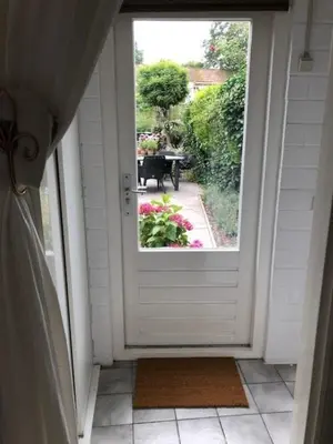 an open door with a view of a garden at BY BABS guesthouse Bergen nh in Bergen