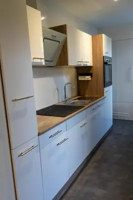 a kitchen with white cabinets and a sink at B&B Sunflower Leiden in Leiden