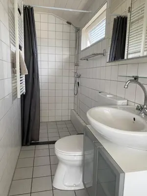 a white bathroom with a toilet and a sink at Chalet Goodmorning in Dirkshorn