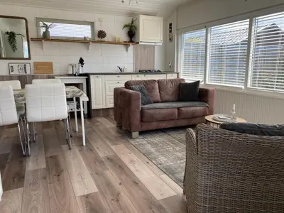 a living room with a couch and a table at Chalet Goodmorning in Dirkshorn