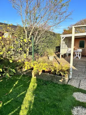 a garden with a fence and some plants at Chalet Goodmorning in Dirkshorn