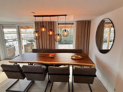 a dining room with a wooden table and chairs at Vakantiehuis aan meertje op Recreatiepark De Wielen - 85 in Sint Maarten