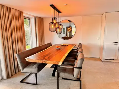 a dining room with a table and chairs and a mirror at Vakantiehuis aan meertje op Recreatiepark De Wielen - 85 in Sint Maarten