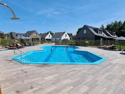 a group of people in a swimming pool at Vakantiehuis aan meertje op Recreatiepark De Wielen - 85 in Sint Maarten