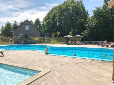 a dog is sitting in a swimming pool at Vakantiehuis aan meertje op Recreatiepark De Wielen - 85 in Sint Maarten