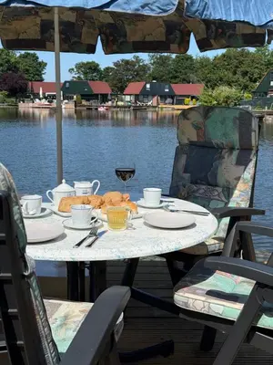a table with food on it next to the water at Stillwater Lodge De Rijd in Nieuwe-Niedorp