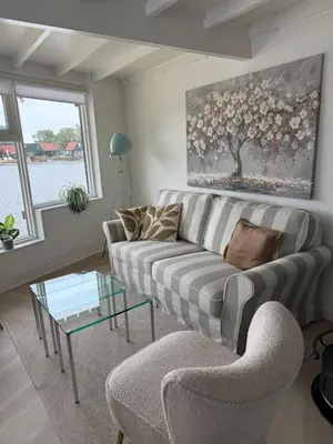 a living room with a couch and a glass table at Stillwater Lodge De Rijd in Nieuwe-Niedorp
