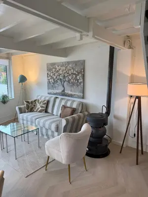 a living room with a couch and a table at Stillwater Lodge De Rijd in Nieuwe-Niedorp