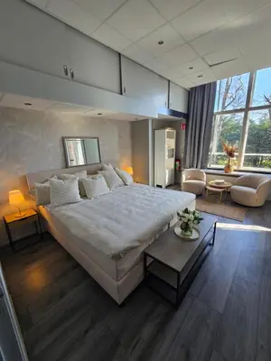 a large bedroom with a large bed and a living room at Hart van Warder in Warder