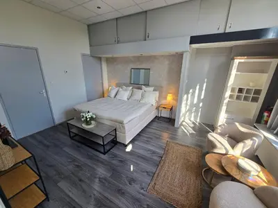 a large bedroom with a bed and a couch at Hart van Warder in Warder
