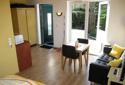 a living room with a table and a couch at Duinen Paradijs Zandvoort in Zandvoort