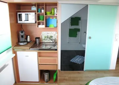 a small kitchen with a sink and a shower at Duinen Paradijs Zandvoort in Zandvoort