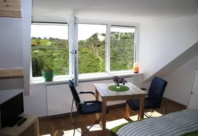 a room with a table and two chairs and a window at Duinen Paradijs Zandvoort in Zandvoort
