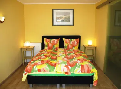 a bedroom with a bed with a colorful comforter at Duinen Paradijs Zandvoort in Zandvoort