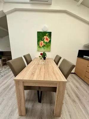 a wooden table with chairs and a vase of flowers on it at Holiday Home Vijfhuizen in Vijfhuizen