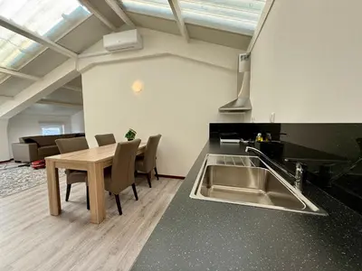 a kitchen with a sink and a table with chairs at Holiday Home Vijfhuizen in Vijfhuizen