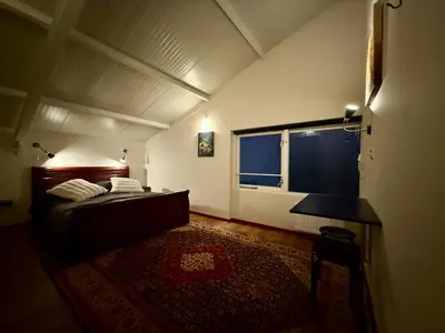 a bedroom with a bed and a table and a window at Holiday Home Vijfhuizen in Vijfhuizen