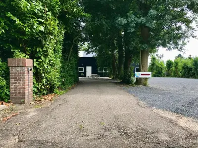 an empty road in front of a house with trees at Holiday Home Vijfhuizen in Vijfhuizen