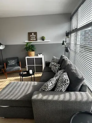 a living room with a gray couch with pillows at De Schelp 67, Free parking in Zandvoort