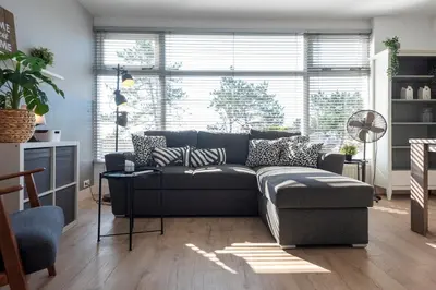 a living room with a couch and a large window at De Schelp 67, Free parking in Zandvoort