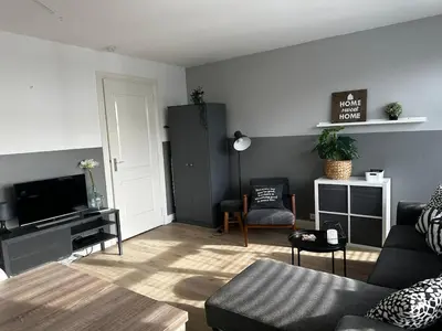 a living room with a couch and a tv at De Schelp 67, Free parking in Zandvoort
