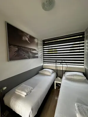two twin beds in a room with a window at De Schelp 67, Free parking in Zandvoort
