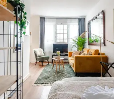 a living room with a yellow couch and a table at Boutique at the beach in Zandvoort