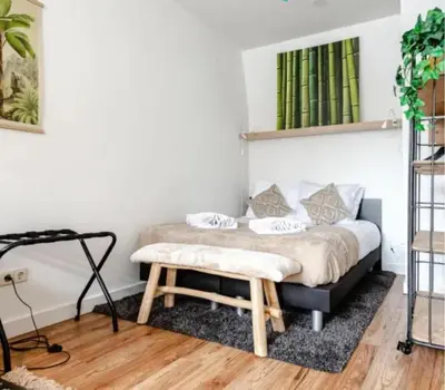 a bedroom with a bed with a bench at Boutique at the beach in Zandvoort