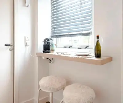 a room with two stools and a window with a bottle at Boutique at the beach in Zandvoort