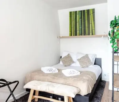 a bedroom with a bed with a bench next to it at Boutique at the beach in Zandvoort