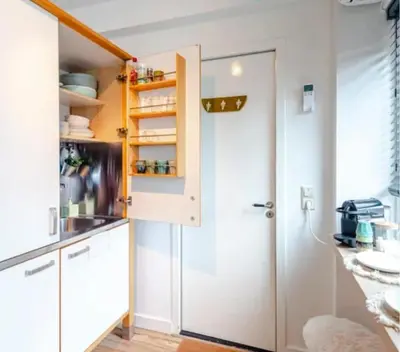 a kitchen with white cabinets and a sink at Boutique at the beach in Zandvoort