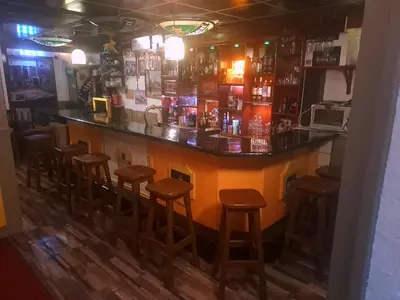 a bar with wooden stools in a room at Slotje in Egmond aan den Hoef