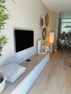 a living room with a flat screen tv on a wall at Casa Camino Del Mar 40 in Noordwijk aan Zee