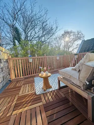 a wooden deck with a bed and a table on it at Casa Camino Del Mar 40 in Noordwijk aan Zee