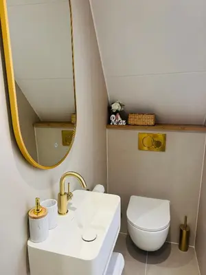 a bathroom with a sink and a toilet and a mirror at Casa Camino Del Mar 40 in Noordwijk aan Zee