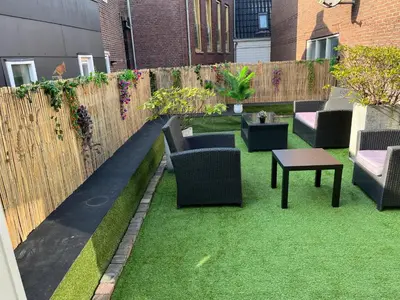 a garden with chairs and a table and a fence at Comfortabel studio 19 min from downtown Amsterdam in Purmerend